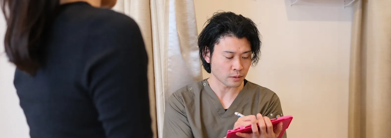 お客様の話を聞く鍼灸整体師